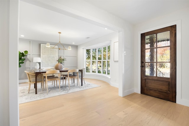 foyer with an inviting chandelier, a healthy amount of sunlight, and light hardwood / wood-style floors