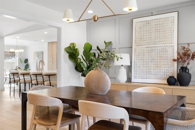 dining area featuring light hardwood / wood-style flooring and an inviting chandelier