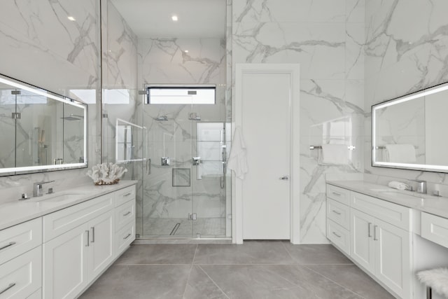 bathroom featuring vanity, a shower with shower door, and tile walls