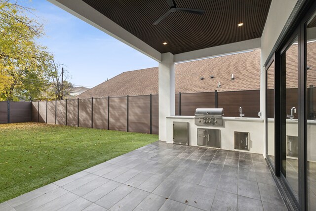 view of patio featuring a grill, ceiling fan, and an outdoor kitchen