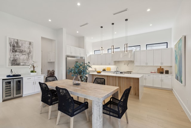 dining area featuring light hardwood / wood-style floors and wine cooler