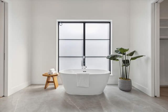 bathroom with a bathing tub and concrete flooring