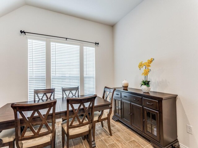 dining space featuring lofted ceiling and light wood-type flooring