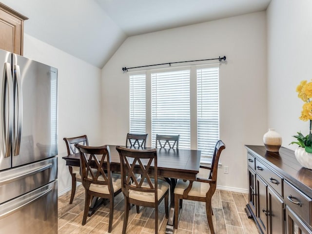 dining space with lofted ceiling and light wood-type flooring