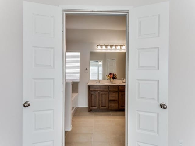 bathroom featuring a washtub, vanity, and tile patterned floors