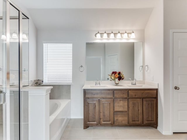 bathroom featuring tile patterned flooring, vanity, and shower with separate bathtub