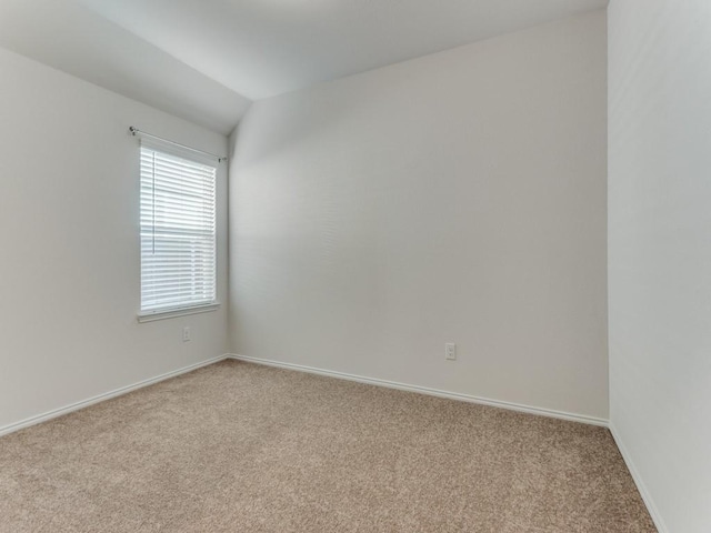 unfurnished room with light carpet and vaulted ceiling