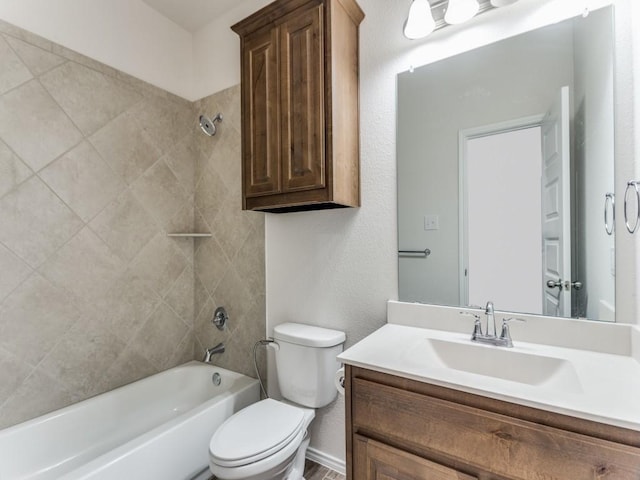 full bathroom featuring tiled shower / bath, vanity, and toilet