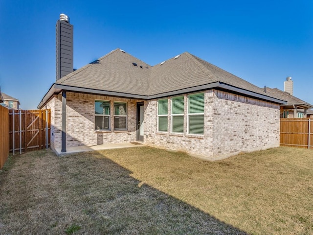 rear view of house featuring a yard and a patio