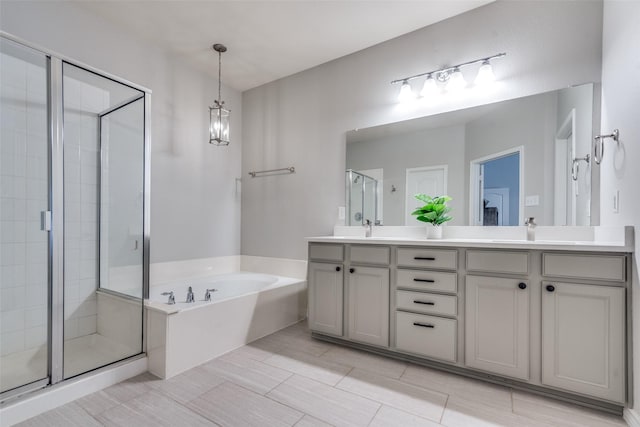 bathroom featuring independent shower and bath, vanity, and a chandelier