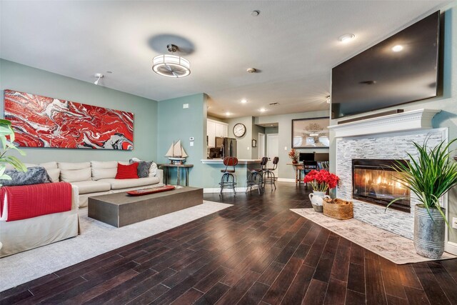 living room featuring hardwood / wood-style flooring and a tiled fireplace