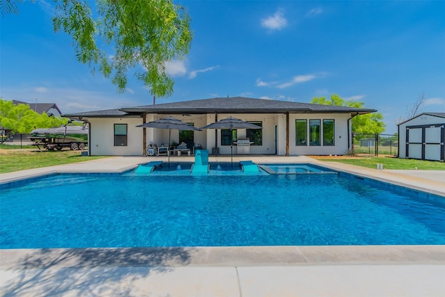 view of pool with a patio and a storage unit