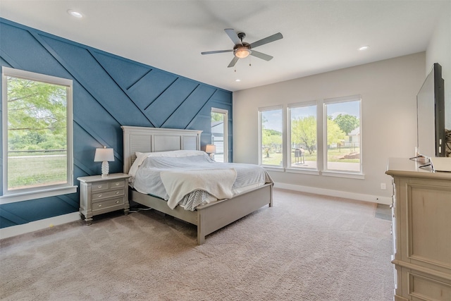 carpeted bedroom with multiple windows and ceiling fan