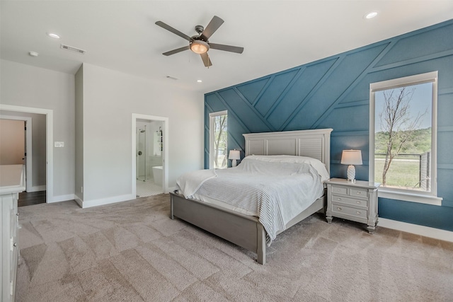 bedroom featuring connected bathroom, ceiling fan, and light carpet