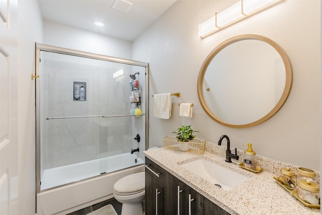 full bathroom with vanity, enclosed tub / shower combo, and toilet