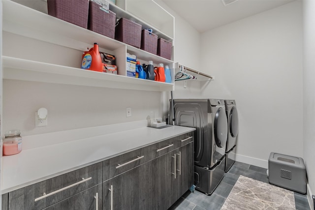 clothes washing area with cabinets and separate washer and dryer