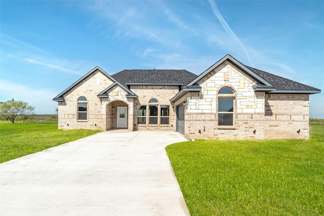 french country inspired facade with a garage and a front yard