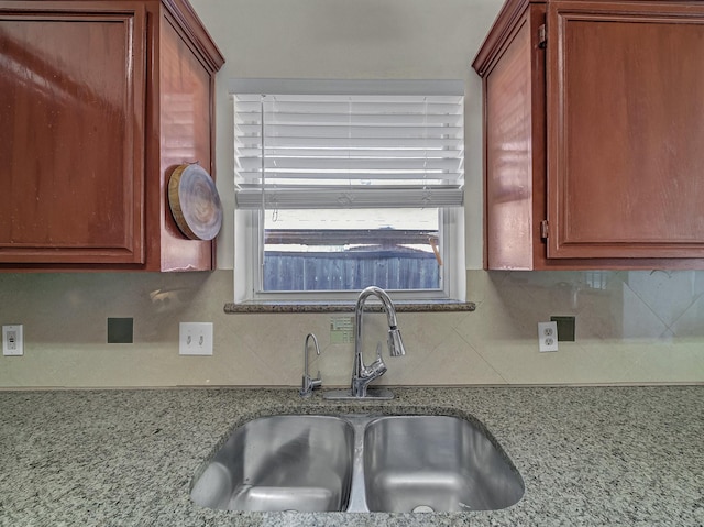 kitchen with tasteful backsplash, sink, and light stone counters