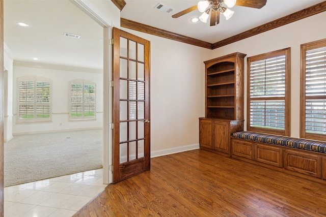 unfurnished office with ceiling fan, a healthy amount of sunlight, light hardwood / wood-style floors, and ornamental molding