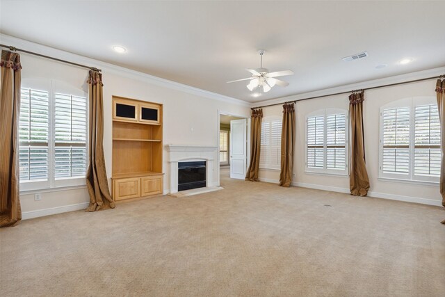 unfurnished living room with light carpet, ornamental molding, and a healthy amount of sunlight