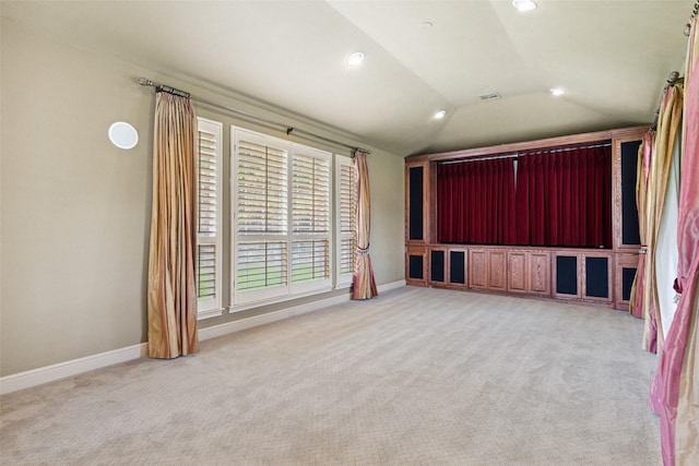 interior space with light colored carpet and vaulted ceiling