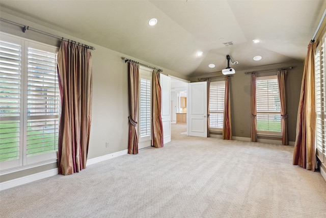 unfurnished bedroom featuring light colored carpet and lofted ceiling