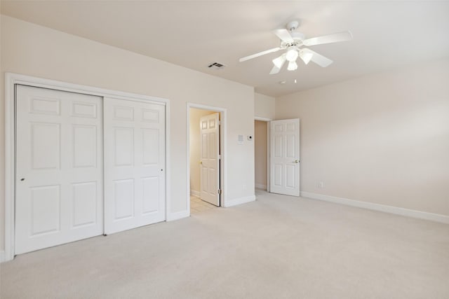 unfurnished bedroom with ceiling fan, a closet, and light carpet