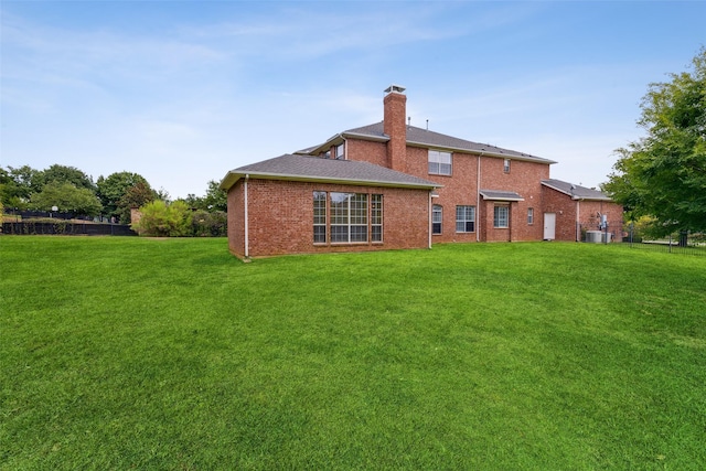 rear view of property with a lawn