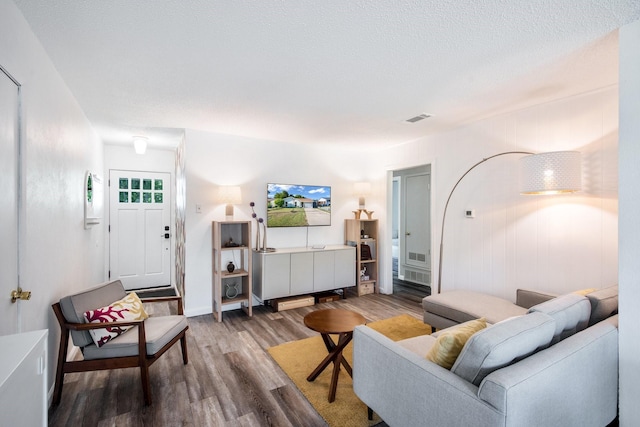 living room with wood-type flooring and a textured ceiling