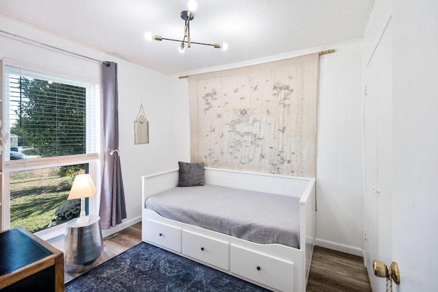 bedroom featuring a notable chandelier, wood-type flooring, and a textured ceiling