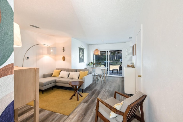 living room with dark hardwood / wood-style flooring and a textured ceiling