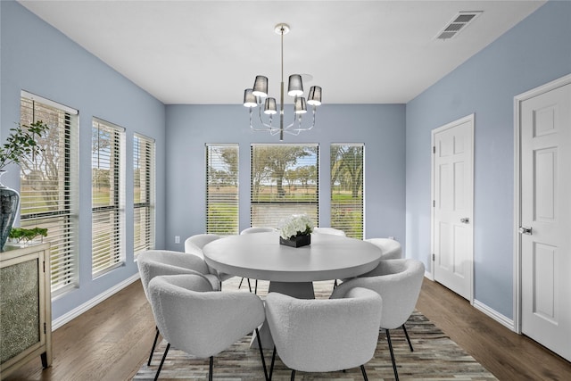 dining space featuring dark hardwood / wood-style flooring and a chandelier