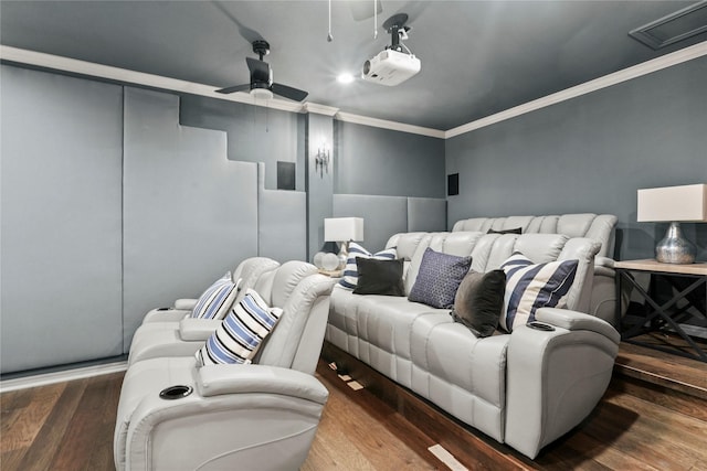 cinema room featuring wood-type flooring, ornamental molding, and ceiling fan