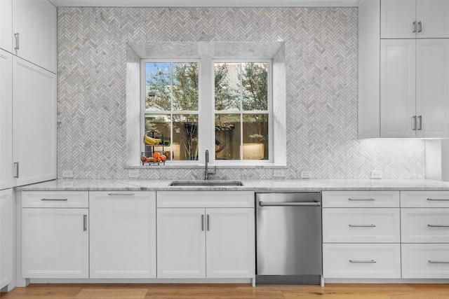 kitchen featuring light stone counters, white cabinetry, sink, and light hardwood / wood-style flooring