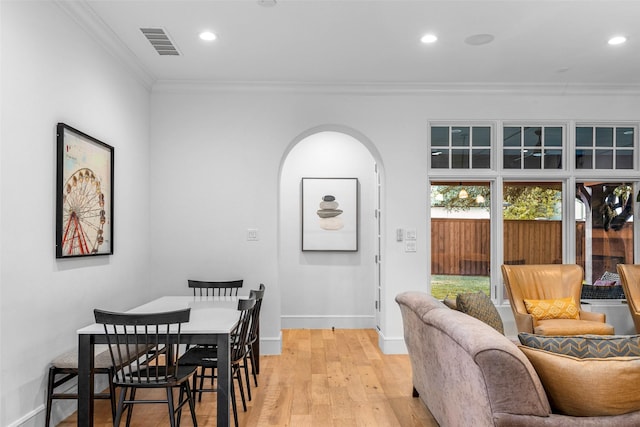 dining space with light hardwood / wood-style flooring and crown molding