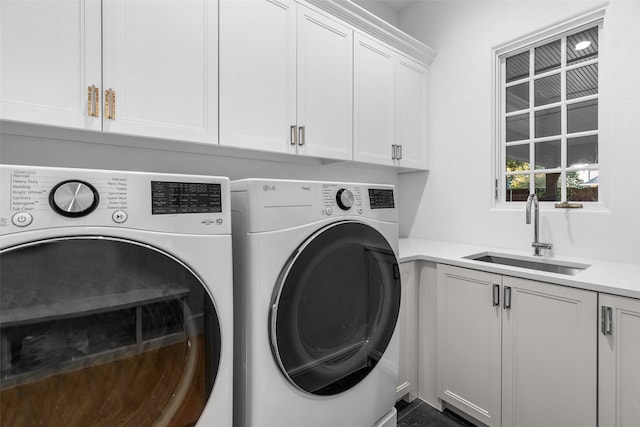 washroom featuring washer and clothes dryer, sink, and cabinets