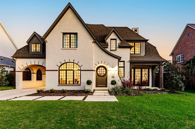 6428 Tulip Ln, Dallas, TX 75230 - french country inspired facade featuring roof with shingles, a chimney, stucco siding, and a lawn