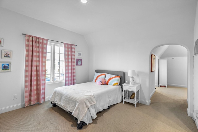 bedroom with lofted ceiling and light carpet