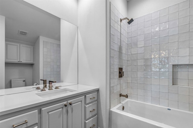 full bathroom featuring toilet, vanity, and tiled shower / bath