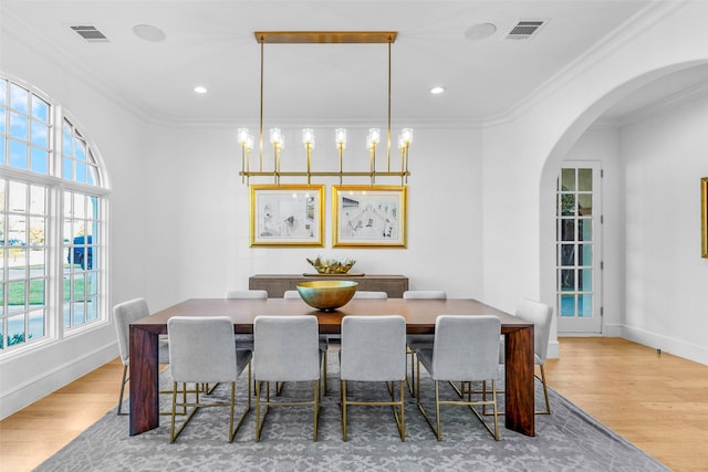 dining space with hardwood / wood-style flooring and ornamental molding