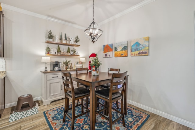 dining room with a notable chandelier, light hardwood / wood-style floors, and ornamental molding