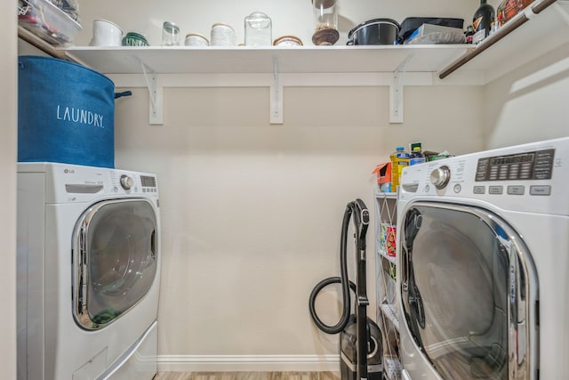 laundry room with light wood-type flooring and washing machine and clothes dryer