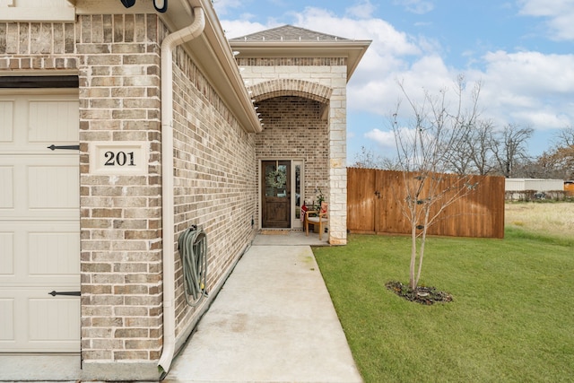 view of exterior entry featuring a lawn