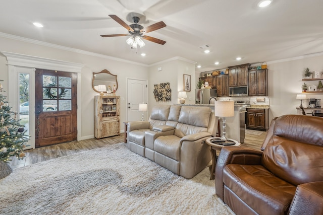 living room featuring ceiling fan, light hardwood / wood-style floors, and ornamental molding