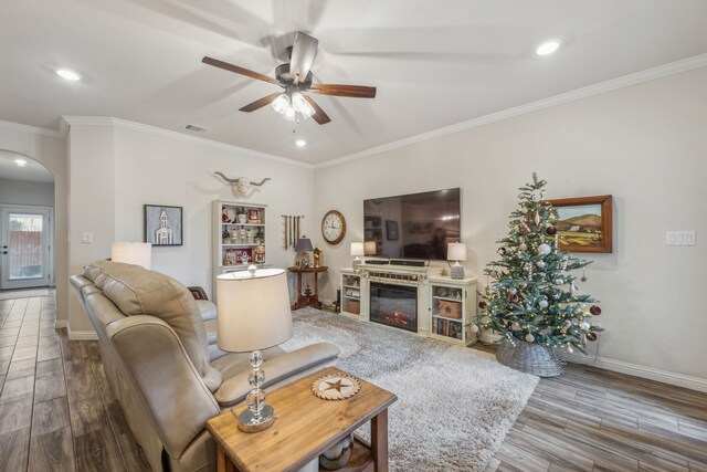 living room with crown molding, hardwood / wood-style floors, and ceiling fan