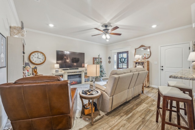 living room with crown molding, light hardwood / wood-style flooring, and ceiling fan