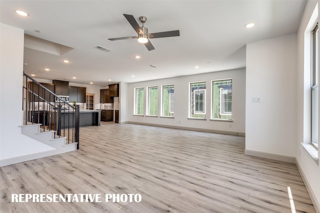 unfurnished living room featuring light hardwood / wood-style flooring and ceiling fan