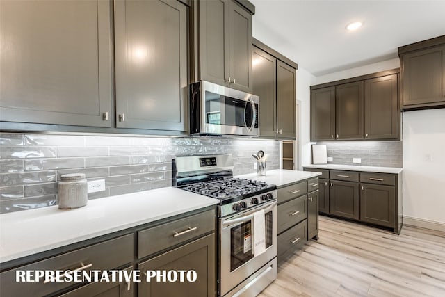 kitchen with backsplash, dark brown cabinets, light hardwood / wood-style flooring, and stainless steel appliances