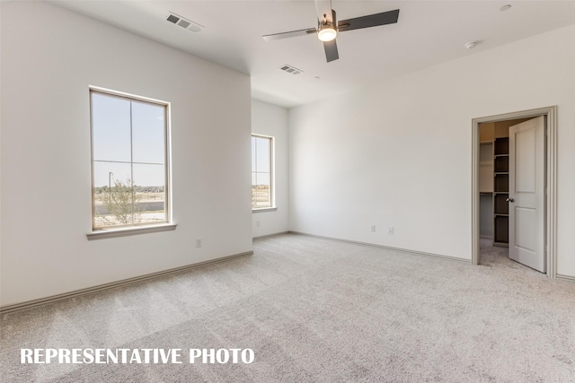 carpeted spare room featuring ceiling fan