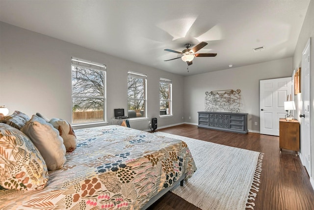 bedroom with visible vents, dark wood finished floors, baseboards, and ceiling fan